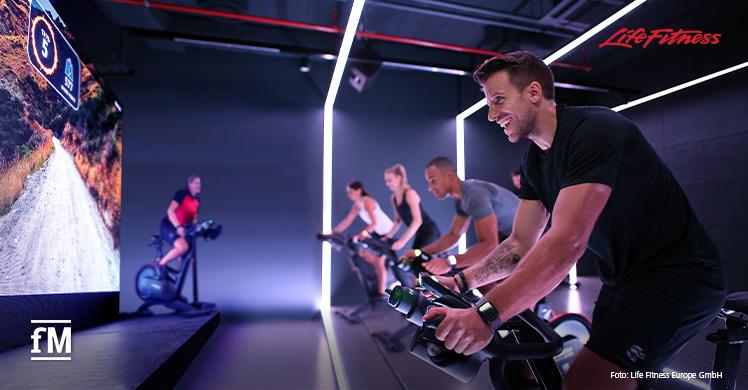 Teilnehmerinnen und Teilnehmer eines inspirierenden Indoor Cycling Kurses auf ICG Bikes, die jetzt zum erweiterten Portfolio von Life Fitness gehören.