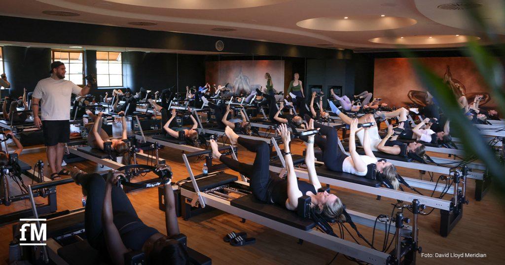 Gruppendynamik pur: Reformer Pilates-Kurs in action – gemeinsames Training mit Fokus auf Körperstabilität