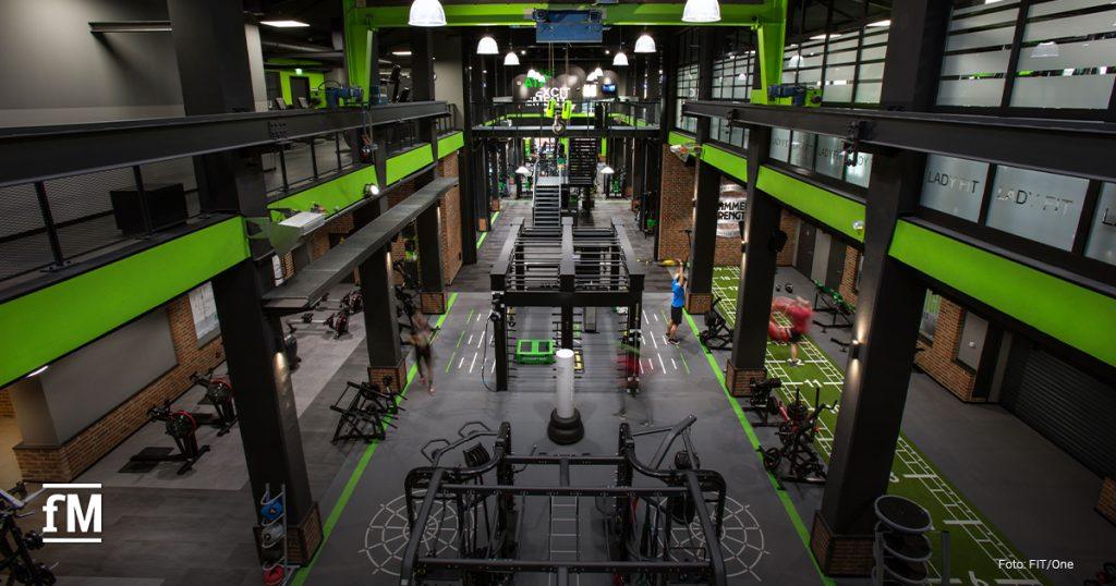 Hochmodernes FIT/One Fitnessstudio mit weitläufiger Trainingsfläche, professionellen Geräten und industriellem Design. Demnächst unter der Marke Fitness First